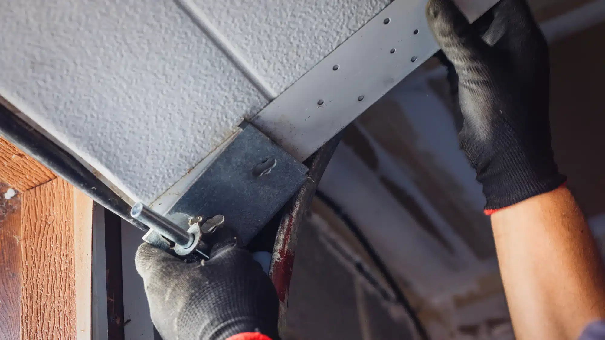 Garage Door Technician Inspecting Common Residential Garage Door Repair Issues In Connecticut Including Springs, Rollers, Tracks, And Opener Components.